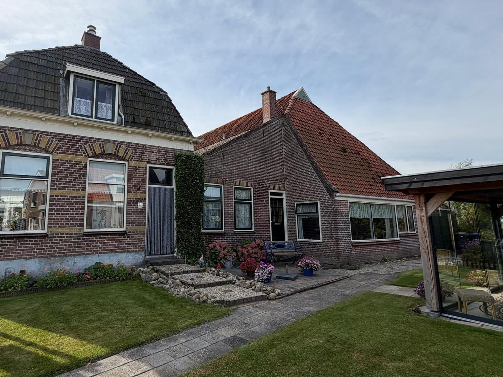 Karakteristieke woning met rode en zwarte pannendaken in Ossenzijl, gekeurd door BSK Bouwadvies